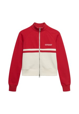 Veste zippée rouge et blanche avec manches longues, col haut, rayures horizontales et logo "SUPERDRY" sur la poitrine.