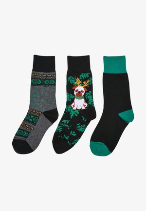 Tre par strumpor: grå med festligt mönster, svarta med renhjord-design och helt svarta med gröna detaljer. Blandning av bomullsmaterial.