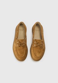 Brown suede shoes with a rounded toe, lace-up design, and white metal eyelets; rubber sole with a textured finish.