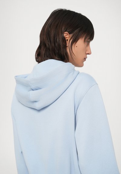 Světlě modrá mikina z bavlněné směsi s kapucí na stažení a volným střihem. Jemná textura s žebrovanými manžetami a lemem.