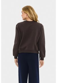 Felpa marrone con scollatura rotonda, polsini e orlo a coste. Presenta una vestibilità comoda, una texture liscia e un design della schiena senza cuciture.