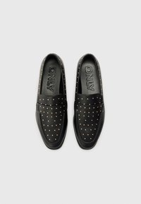 Zwarte loafers van glad leer, met gouden studaccenten en een gestikte design. De binnenkant heeft een geperst "ONLY" logo.