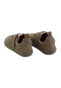 Zapatos de ante marrón con una correa de velcro, punta redondeada y suela baja de goma. Presentan detalles de costura y una superficie suave y texturizada.