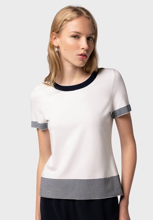 Weißes T-Shirt mit kurzen Ärmeln, navyfarbenem geripptem Rundhals und gestreiftem Saum. Hergestellt aus weichem Stoff, mit horizontalen Streifendetails.