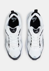 White athletic shoes with black accents, mesh upper, rounded toe, and contrasting textured sole. Features flat laces and a pull tab.
