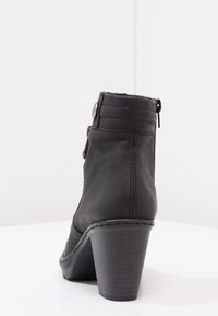 Czarne skórzane botki za kostkę na wysokim obcasie, z bocznym zamkiem błyskawicznym i dekoracyjnymi guzikami. Gładka faktura i wyraźne detale przeszycia.