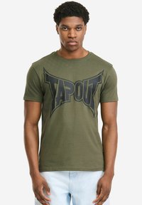 Olivgrünes Baumwoll-T-Shirt mit kurzen Ärmeln, das ein großes schwarzes "TAPOUT"-Logo in einem fetten, kantigen Design über die Brust zeigt.