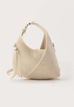 Sac à main beige en forme de croissant avec textures de tissus mélangées, poignée courte et bandoulière amovible, sur fond clair.