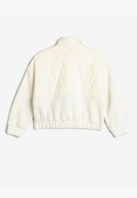 Sweat à manches courtes blanc avec un dessus matelassé et une partie inférieure lisse, équipé de poignets et d'une taille côtelés. Design de col standard.