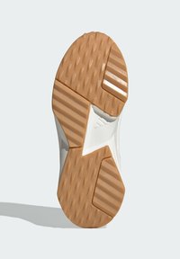 Suela de zapato con un patrón texturizado que presenta surcos elevados y secciones planas, principalmente en colores marrón y blanco, etiquetada como "ADIWEAR".
