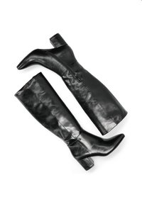 Bottes noires en cuir montantes avec un bout pointu et un talon bloc. Elles présentent une fermeture éclair sur le côté et une texture lisse sur toute la tige.