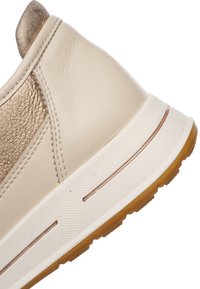 Sneaker beige chiaro con un accento dorato testurizzato. Presenta una tomaia in pelle liscia, una suola imbottita e una suola esterna in gomma patterned.