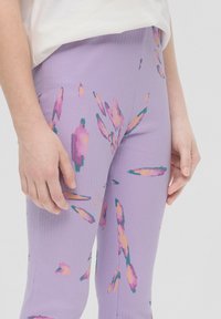 Lila Rippleggings mit einem floralen Muster in Pink, Orange und Teal, mit einer anliegenden Passform und mittelhoher Taille.