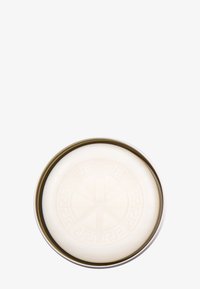 Rund metallbehållare med en gyllene kant. Insidan har en slät, krämfärgad yta med ett präglat geometriskt mönster.