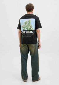 Must beeline musta cactuse graafika helesinis taustal, valgetes tähtedes "ORIGINALS SINCE 1990" tekstiga.