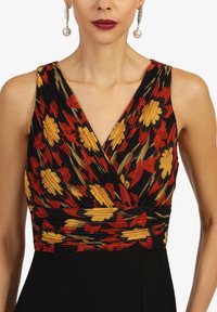 Kleid mit Blumenmuster, das ein schwarzes, plissiertes Oberteil mit roten, gelben und grünen Blumen zeigt. Tiefes V-Ausschnitt und schwarzer Rock. Elegantes Design.