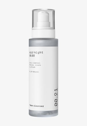 Gjennomsiktig plastflaske med hvit pumpe, grå bunn, minimalistisk design. Etiketten sier "mid/night" og "face cleanser," 96,2 % naturlige ingredienser.