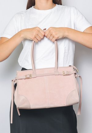 Borsa in suede rosa blush con doppio manico superiore, cinturino sottile rimovibile, dettagli in hardware dorato e cuciture decorative.