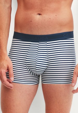 Mannelijke torso met marineblauw-wit horizontaal gestreepte boxershort met een donkere tailleband met het label "CALIDA."