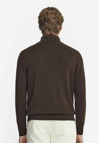 Brun stickad tröja med hög krage, ribbade ärmslut och nederkant. Mjuk textur, figursydd design, som visar bakvy på en ljus bakgrund.