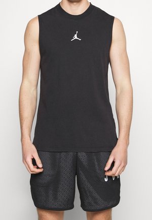 Canottiera nera senza maniche in cotone, con un piccolo logo Jumpman bianco sul petto, abbinata a pantaloni corti in rete neri.