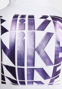Sudadera blanca con un gran estampado geométrico reflectante en color púrpura de la palabra "NIKE" en la parte posterior. Tela suave con una textura blanda.