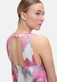 Ärmelloses Blütenkleid mit einem pinken und grauen Muster, offener Rücken mit Schlüsselaugen-Design und diskretem Reißverschluss. Glatte Stoffstruktur.