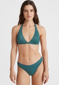 Tyrkysový bikiny set s halter krkom a trojuholníkovým vrchom a nízko vystihujúcimi nohavičkami, vyrobený z hladkého, elastického materiálu s minimom švov.