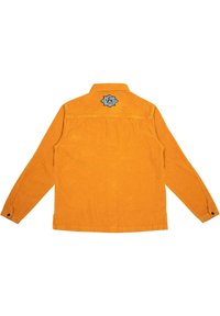 Orange corduroy shirt jacket with long sleeves, buttoned cuffs, and a black embroidered logo on the back. Textured fabric and classic collar.