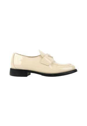 Mocassin crème brillant avec une bride et une petite boucle, petit talon et semelle noirs, vu de côté sur fond blanc.
