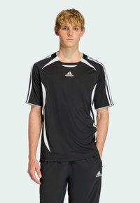 Czarna koszulka sportowa z białymi akcentami i logo Adidas. Krótkie rękawy, okrągły dekolt i teksturowany materiał. Odpowiednia do aktywności sportowych.