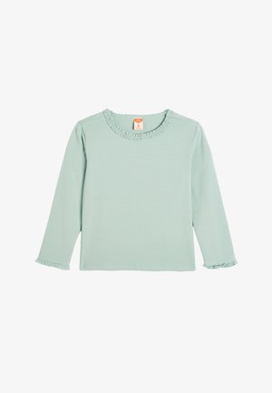 Bawełniana bluzka z długim rękawem w jasnym odcieniu miętowej zieleni, z falbaną przy dekolcie i mankietach. Prosta, gładka tekstura bez wzorów lub akcentów.