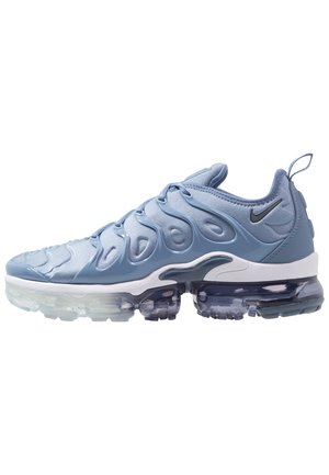 Hellblauer Nike Air VaporMax Plus Sneaker mit transparenter Sohle, wellenförmigem Obermaterial und kleinem schwarzem Nike-Swoosh an der Ferse.