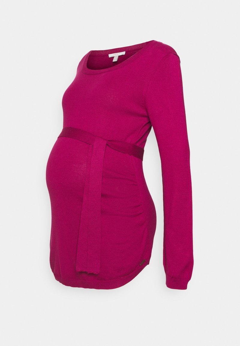 Maternity sweater in vibrant fuchsia with a round neckline, long sleeves, and adjustable tie at the waist. Soft knit texture with gathered sides.