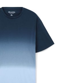 T-shirt dalla vestibilità ampia con una gradazione di colore dal blu navy scuro al blu chiaro, realizzato in cotone morbido, con colletto rotondo e maniche corte.