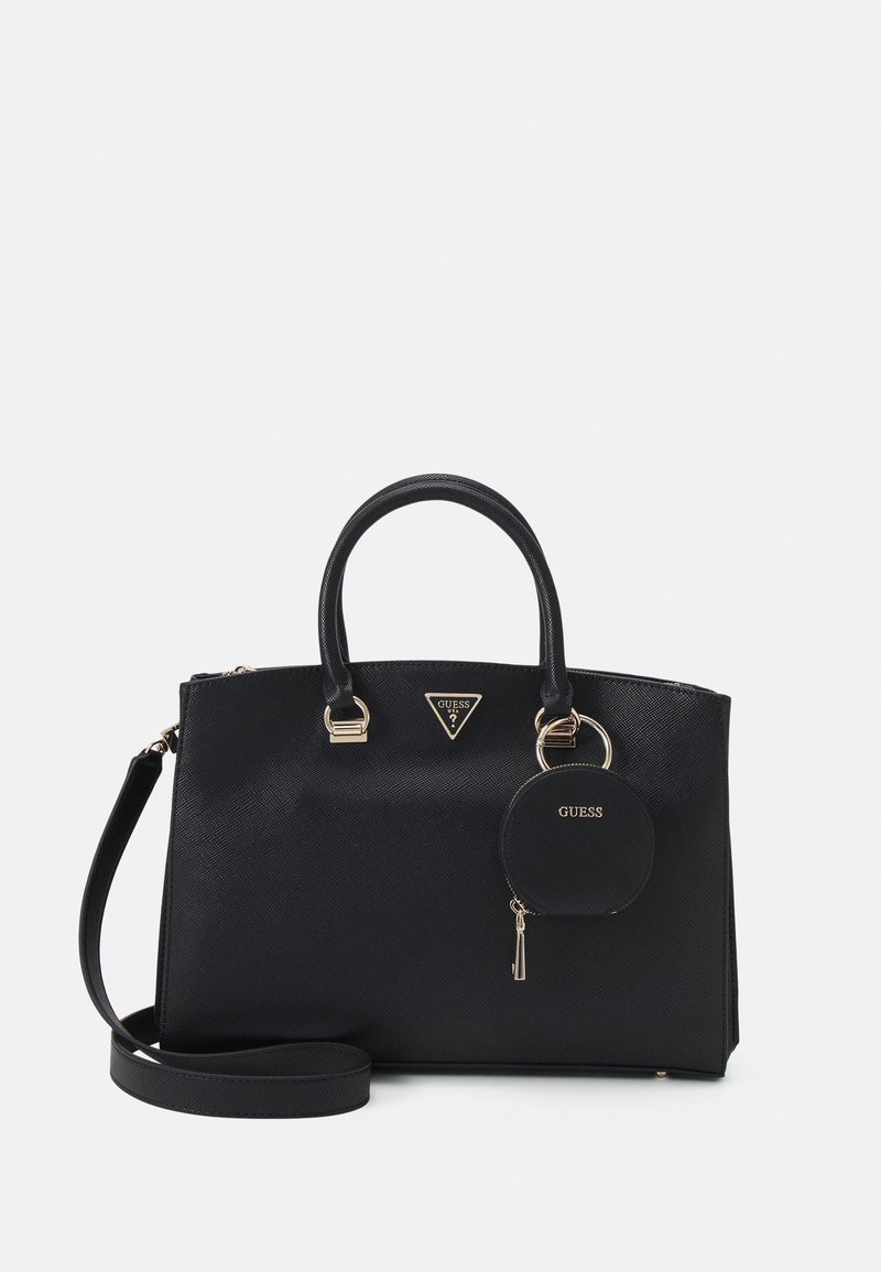 Sac à main noir Guess avec doubles poignées, bandoulière détachable et petite pochette ronde pour pièces attachée à un anneau doré à l'avant.