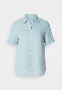 Chemise en lin bleu clair à manches courtes avec ouverture boutonnée devant et poignets repliés, dotée d'un col classique et d'une coupe ample.