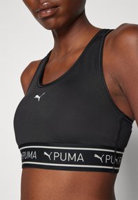 Puma KEEPS BRA - Športni modrček s srednjo podporo - black