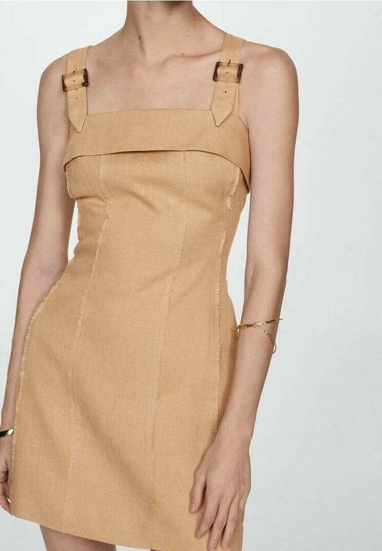 Robe courte en lin beige avec encolure carrée, bretelles réglables ornées de boucles brunes, et coutures décoratives le long des coutures.