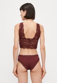 Bordeaux blondebh med blomstermønster og brede stropper; matchende bordeaux blondetraperte truser. Teksturert detaljer gjennom hele.
