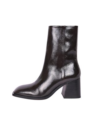 Bottine en cuir noir avec une finition brillante, un bout pointu et un talon carré. Texture lisse et silhouette élancée pour un look moderne.