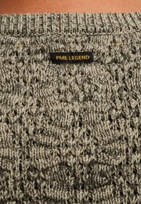 Grijze gebreide trui met een gestreept patroon en een zwart label met "PME LEGEND" in goud, gesitueerd aan de achterkant van de hals.