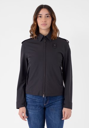 Giacca nera con chiusura a zip, colletto a punta e tasche laterali. Presenta una tasca sul petto e polsini con bottoni. Tessuto dalla texture liscia.