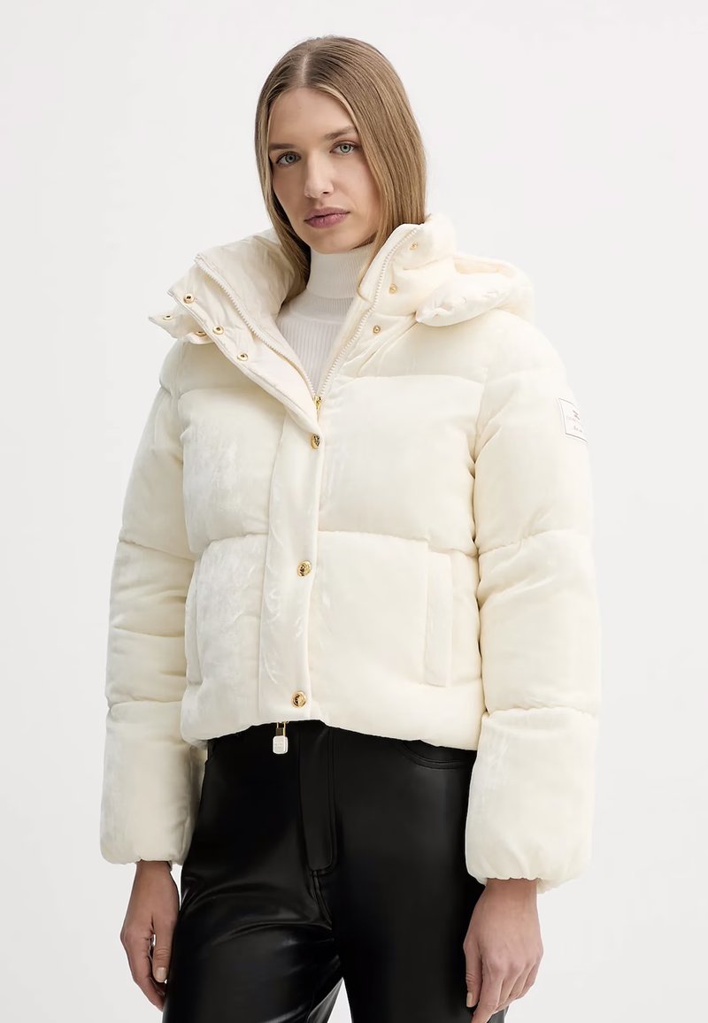 Giacca a vento bianca con cappuccio, caratterizzata da chiusura a zip e bottoni automatici, accessori in oro, design trapuntato e polsini elasticizzati.