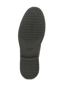 Semelle de chaussure avec bande de roulement en caoutchouc noir texturé présentant des motifs ondulés et ponctués, étiquetée avec la marque Geox et un design breveté.