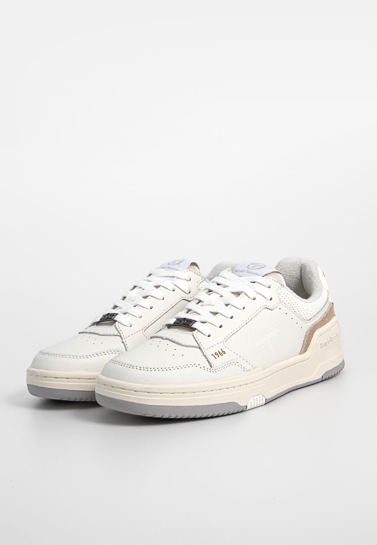 Sneaker bianche in pelle con finitura testurizzata, dotate di una suola grigia morbida e sottili accenti beige. Inclusi fori di ventilazione e lacci.