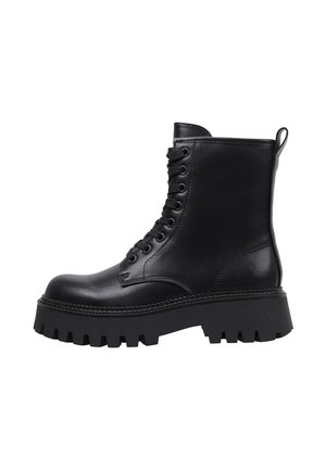 Bota de combate negra de cuero con cordones, suela gruesa con tacos y caña alta hasta el tobillo, perfil lateral sobre fondo blanco.