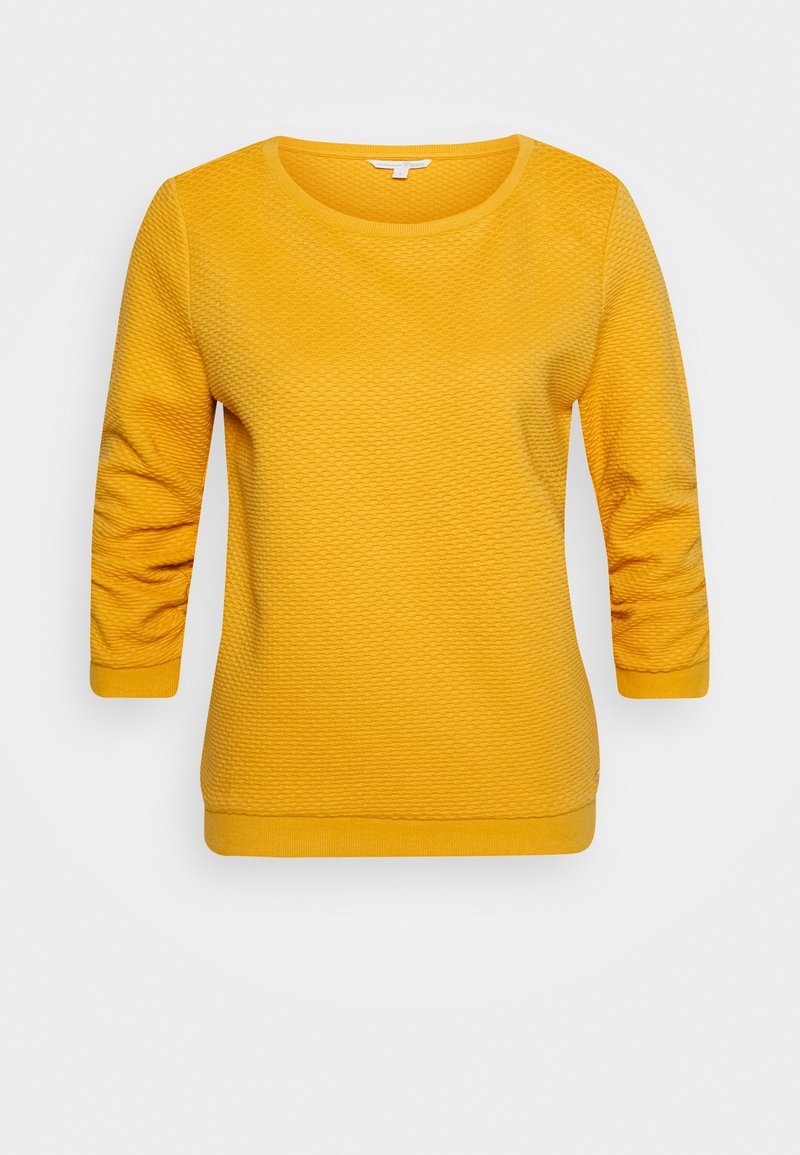 Pull tricot texturé jaune à manches trois-quarts, encolure ronde, avec poignets et ourlet côtelés, présenté sur un fond blanc.