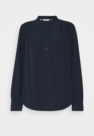Marineblaue Bluse mit langen Ärmeln, hohem Kragen, Knopfleiste, gerafften Schulterdetails und breiten Manschetten.