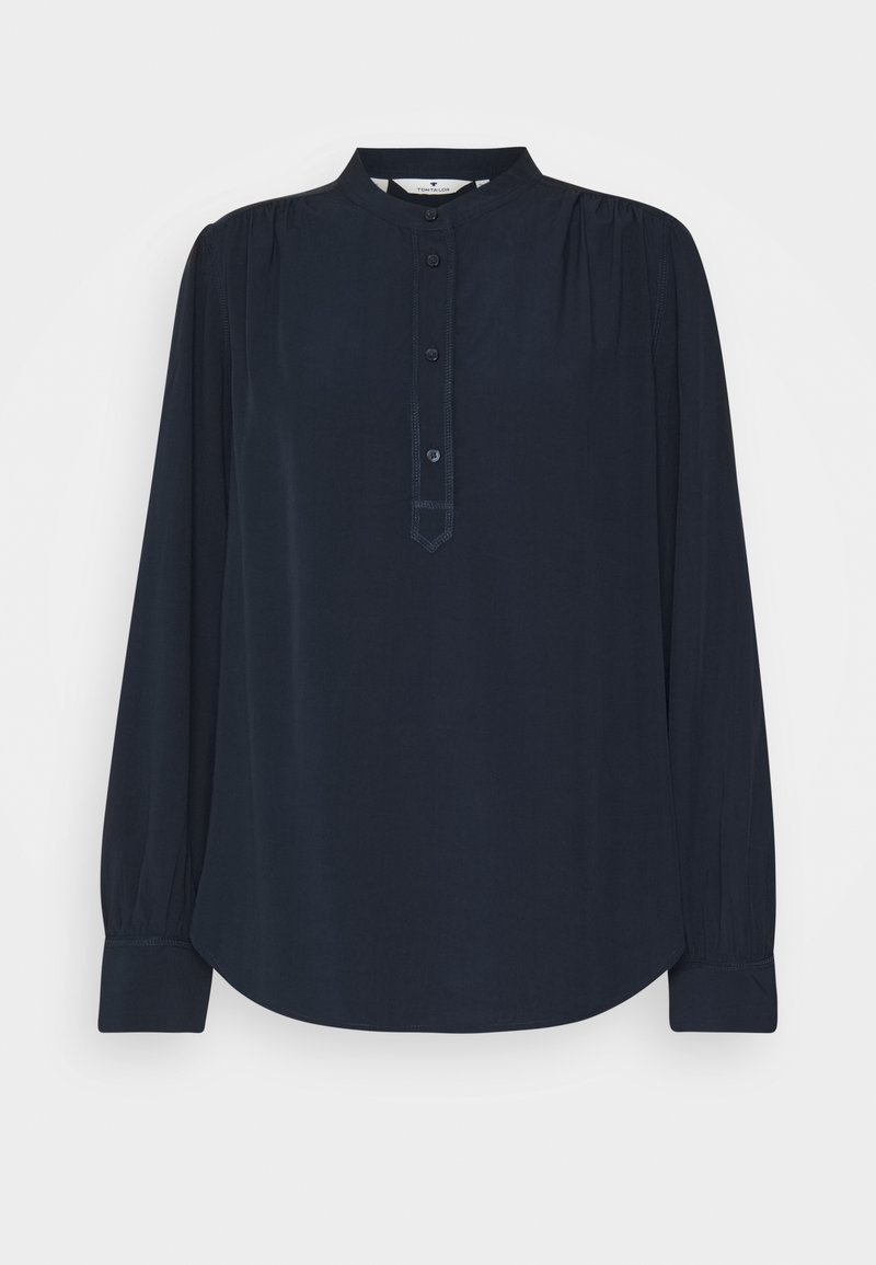 Blusa blu navy a maniche lunghe con colletto alto, pattina con bottoni, dettagli arricciati sulle spalle e polsini larghi.